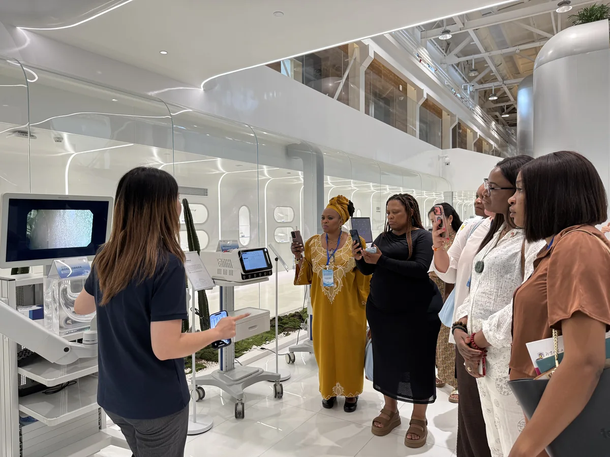 A Saluentra Medical representative demonstrates the AICAM system to international visitors.